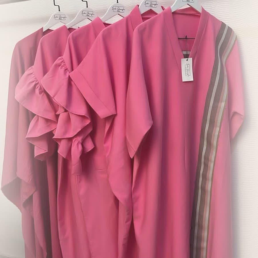 Pink maxi dresses and kaftans on hangers