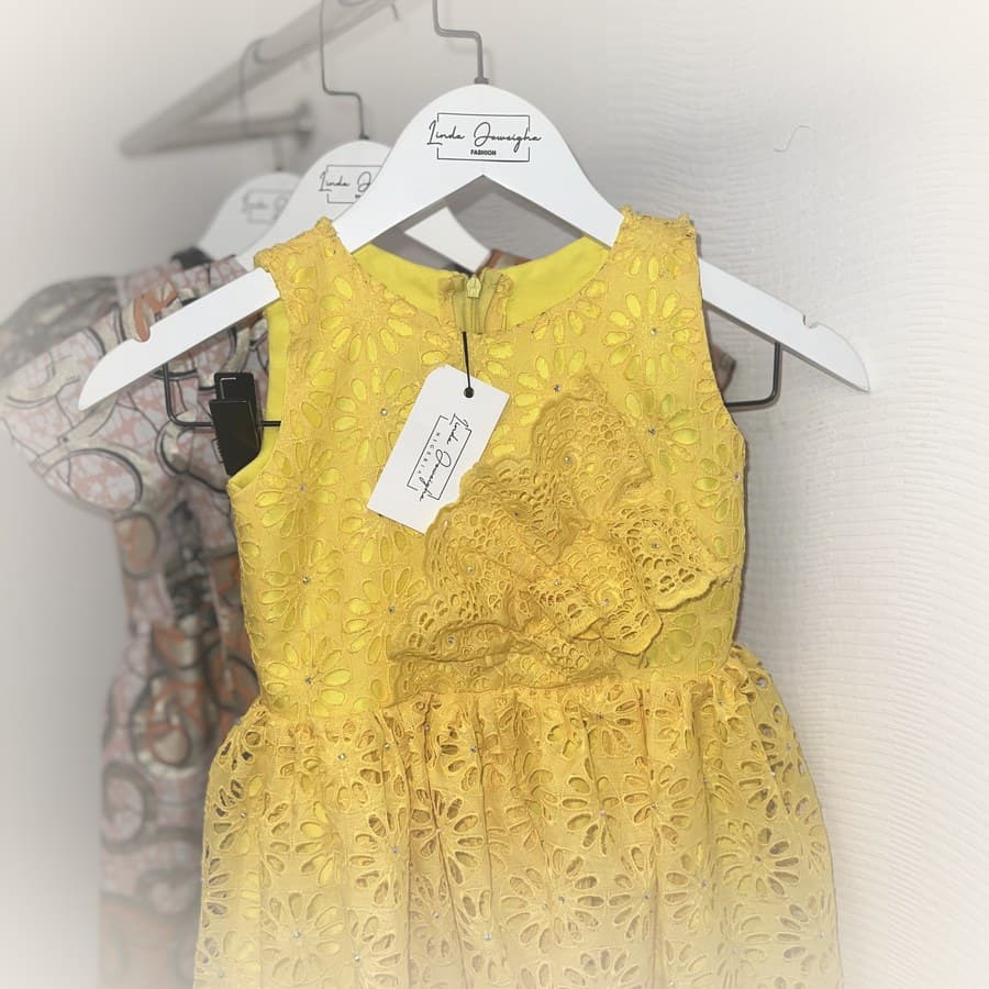 Yellow eyelet lace dress with rhinestone detailing on hanger