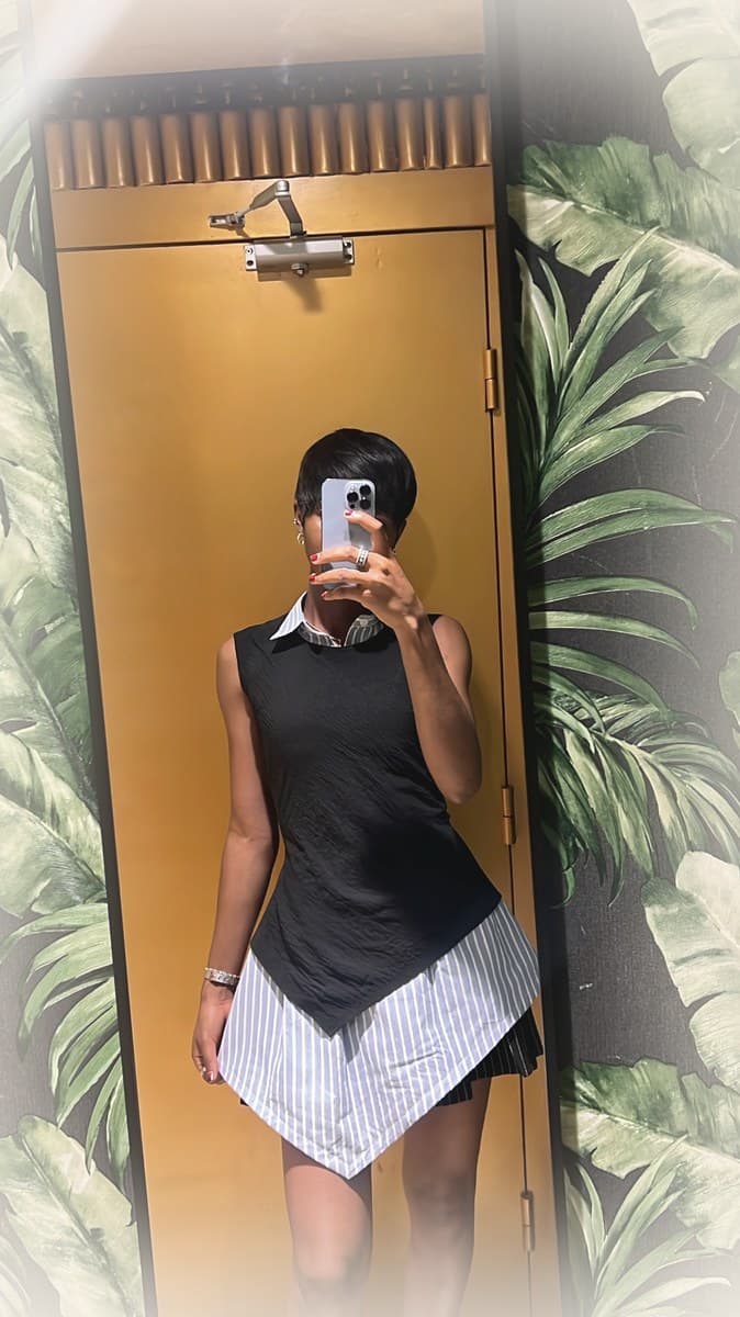 LJ look — black textured top layered over white shirt with asymmetrical striped skirt